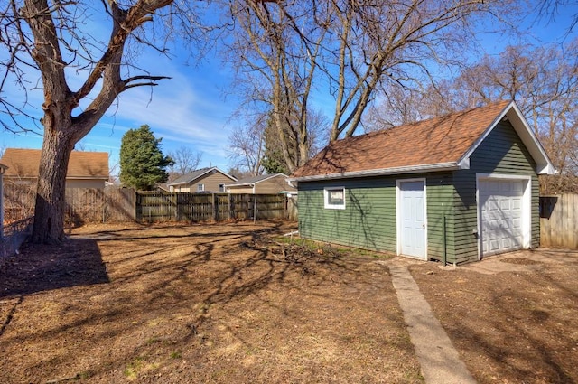 detached garage with fence and driveway