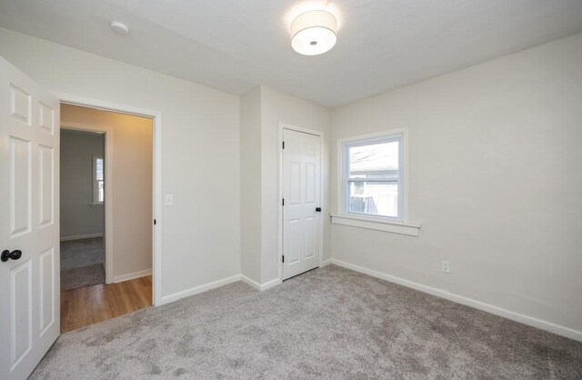 unfurnished bedroom with a closet, baseboards, and carpet floors