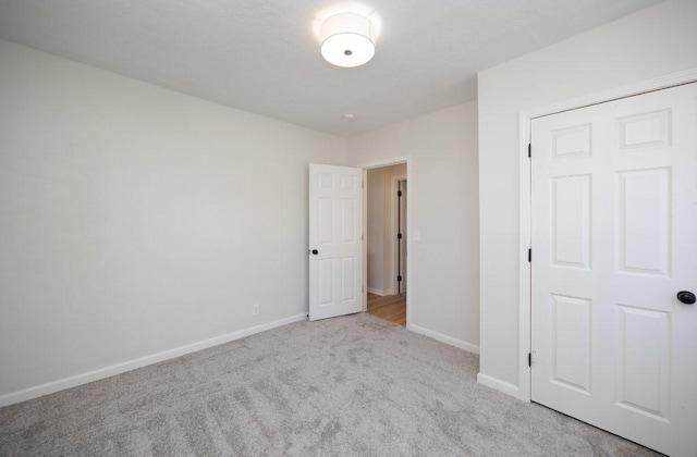 unfurnished bedroom with carpet flooring and baseboards