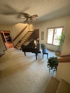 1301 Florida Ave, Ames, IA 50014 - living room with a textured ceiling, stairway, a ceiling fan, and carpet floors