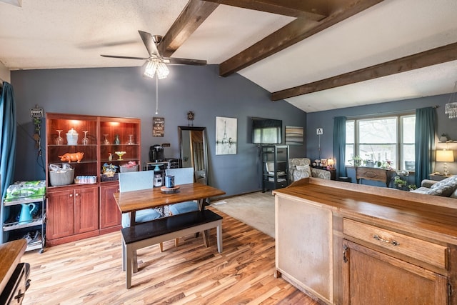 interior space with wood counters, light wood-style flooring, lofted ceiling with beams, open floor plan, and a ceiling fan