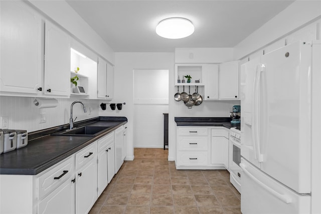 kitchen with dark countertops, white appliances, open shelves, and a sink