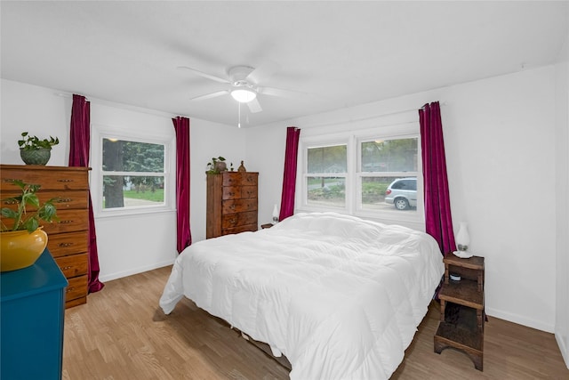 bedroom featuring baseboards, wood finished floors, and a ceiling fan