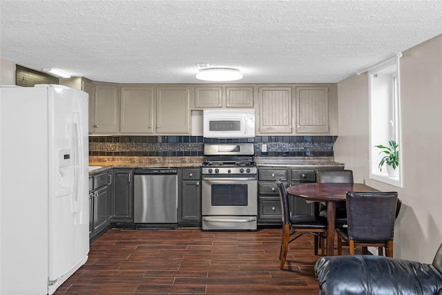 kitchen featuring dark wood-style floors, gray cabinetry, backsplash, and stainless steel appliances