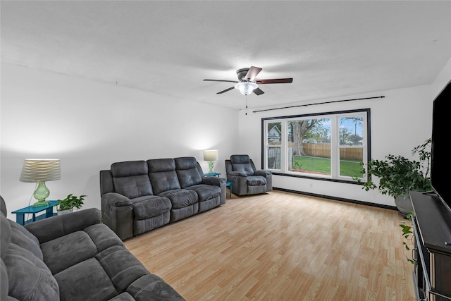 living room featuring a ceiling fan and light wood-style flooring