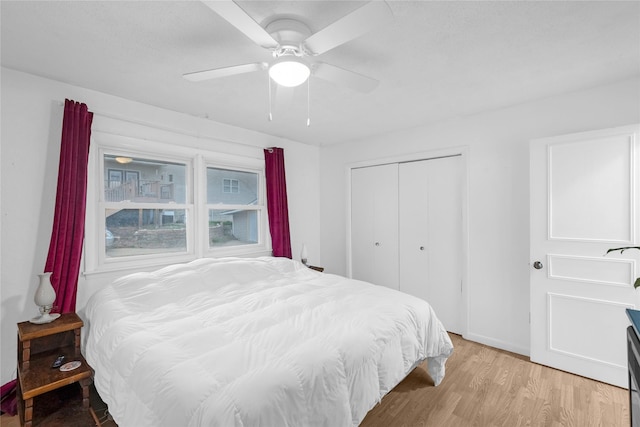 bedroom with a closet, a ceiling fan, and light wood-style floors