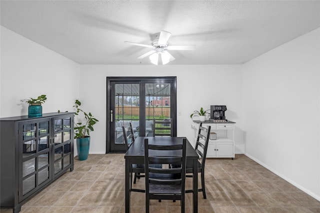 tiled dining area featuring a textured ceiling, ceiling fan, and baseboards
