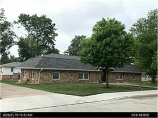 view of front of home with a front yard and stone siding