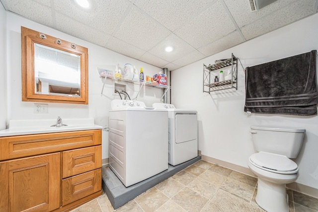 washroom featuring recessed lighting, washing machine and clothes dryer, laundry area, and baseboards