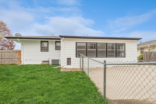 back of house featuring cooling unit, a yard, and a fenced backyard