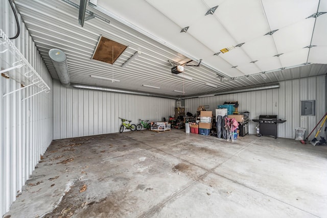 garage with a garage door opener, electric panel, and metal wall