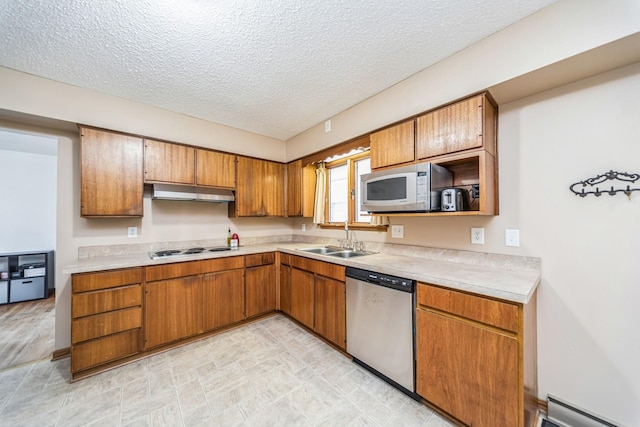 kitchen with light countertops, white appliances, a baseboard radiator, and a sink