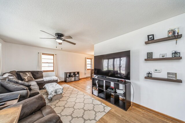 living area featuring a ceiling fan, wood finished floors, and a textured ceiling