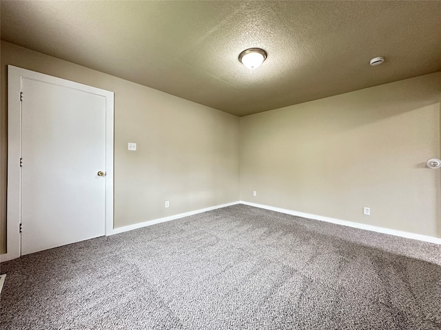 carpeted empty room with a textured ceiling and baseboards