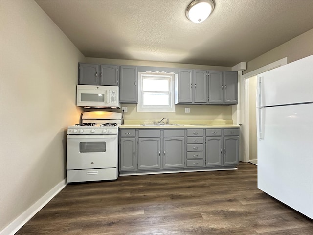 kitchen featuring a sink, gray cabinets, and white appliances