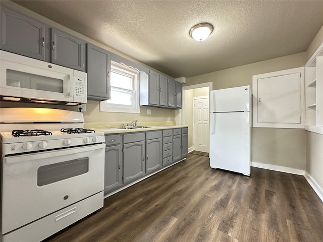 kitchen featuring gray cabinets, white appliances, baseboards, a textured ceiling, and dark wood-type flooring