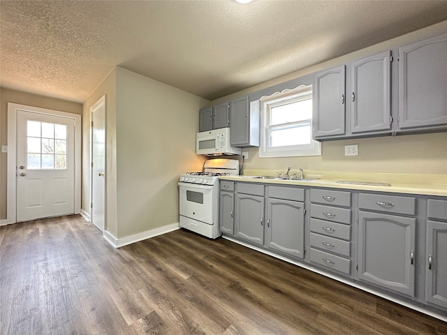 kitchen featuring gray cabinetry, white appliances, a textured ceiling, and a sink