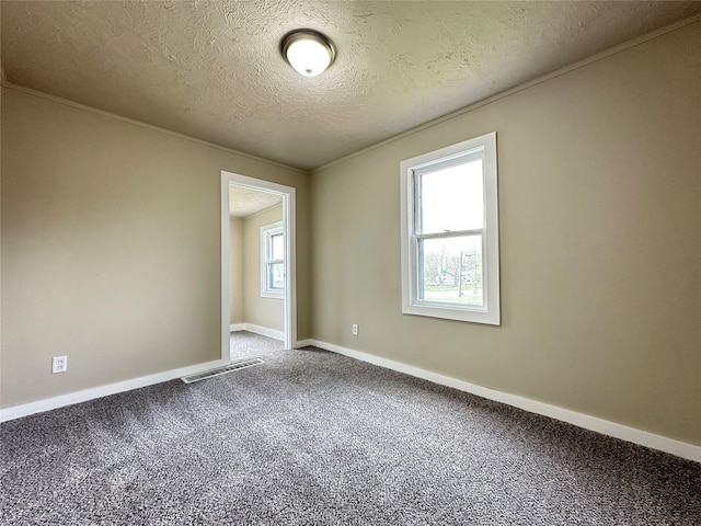 carpeted empty room with baseboards, visible vents, a textured ceiling, and crown molding