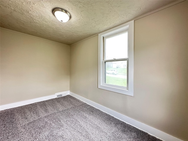 unfurnished room with a textured ceiling, visible vents, dark carpet, and baseboards