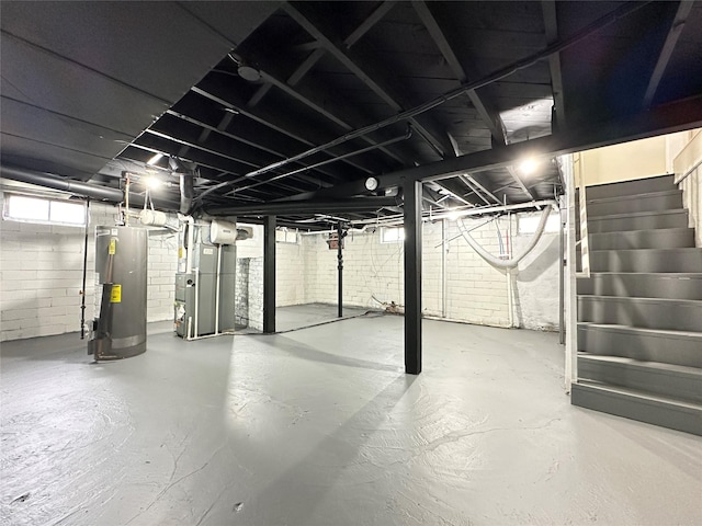 below grade area with water heater, heating unit, and stairway