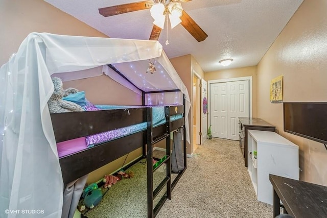 bedroom with ceiling fan, a textured ceiling, and carpet flooring
