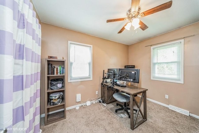 carpeted office featuring baseboards, visible vents, and a ceiling fan