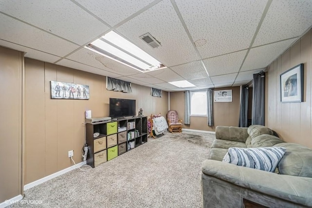 carpeted living room with visible vents, a paneled ceiling, and baseboards