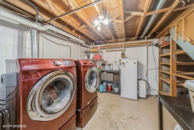 clothes washing area featuring independent washer and dryer, concrete block wall, and laundry area