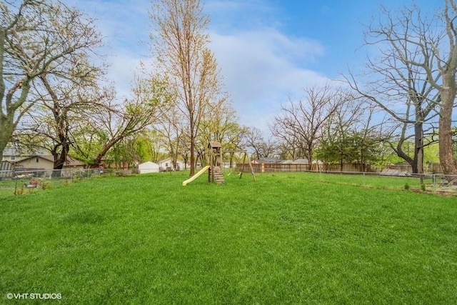 view of yard with fence and a playground