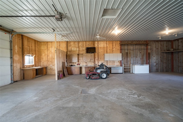 garage featuring a garage door opener and wooden walls