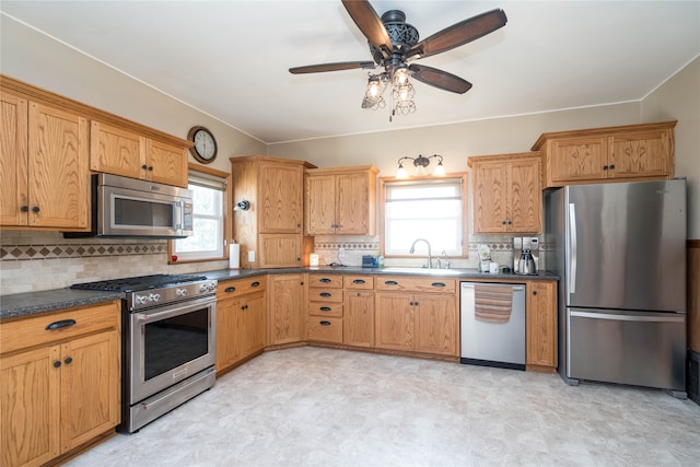 kitchen with tasteful backsplash, a healthy amount of sunlight, appliances with stainless steel finishes, and a sink