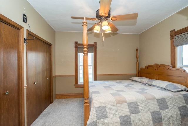 carpeted bedroom featuring a closet, ceiling fan, and baseboards