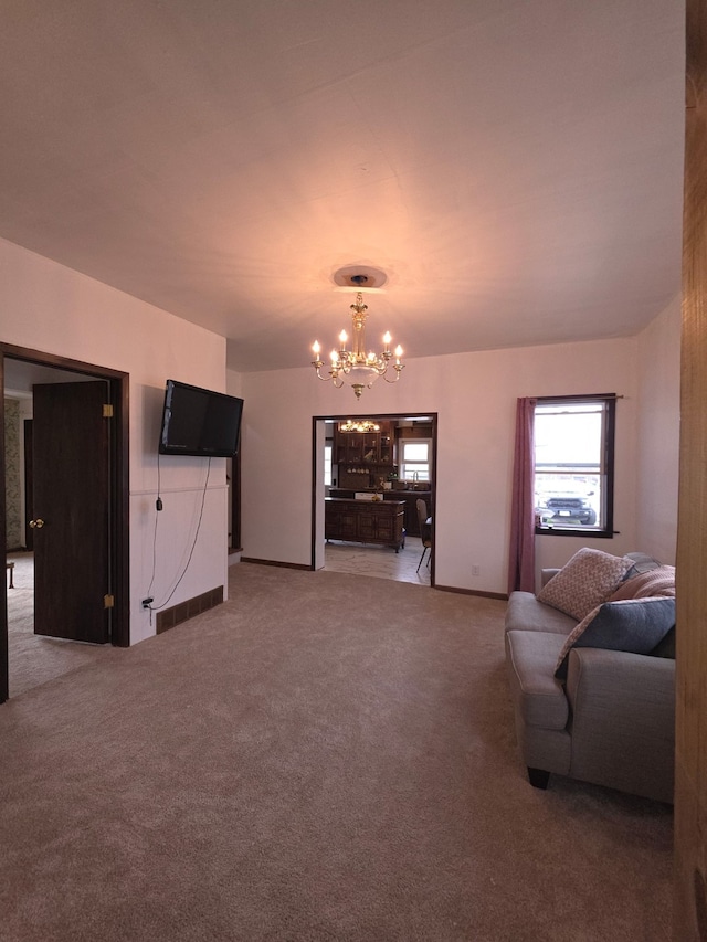 carpeted living room featuring baseboards and a notable chandelier
