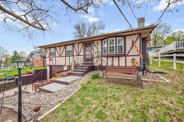 view of front of property featuring a chimney, fence, stucco siding, and a garage