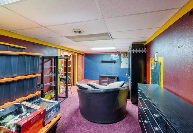 interior space featuring visible vents, a textured wall, and a drop ceiling