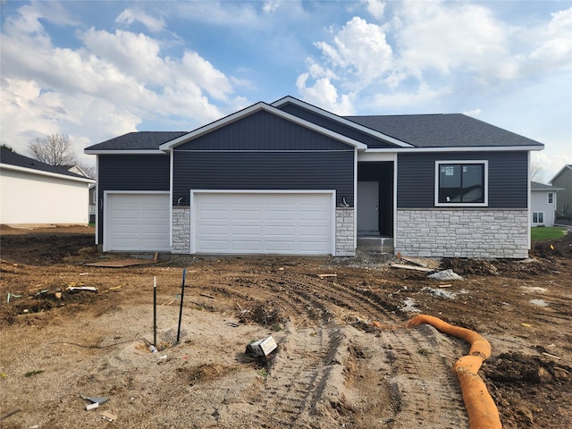 view of front facade featuring a garage, driveway, stone siding, and a shingled roof
