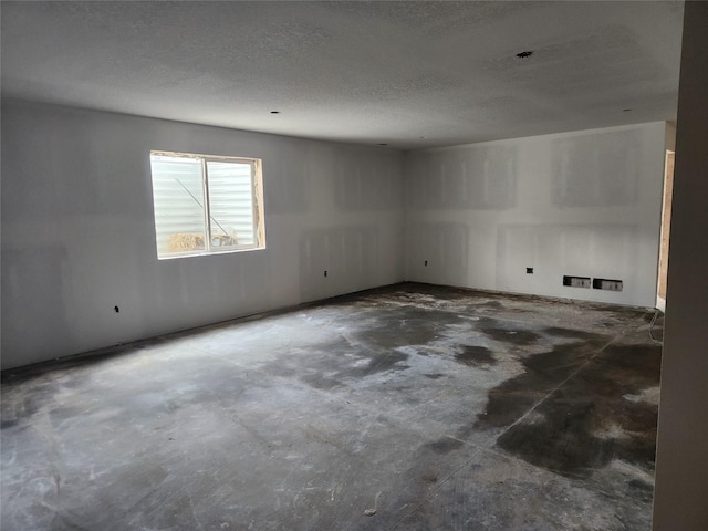 unfurnished room featuring unfinished concrete flooring and a textured ceiling