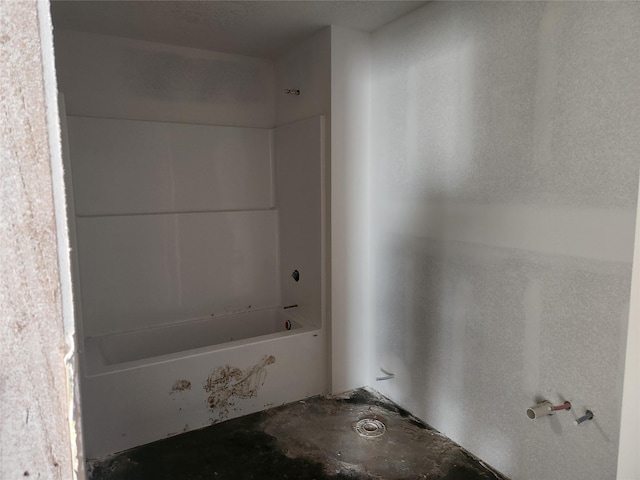 full bathroom with washtub / shower combination and concrete floors