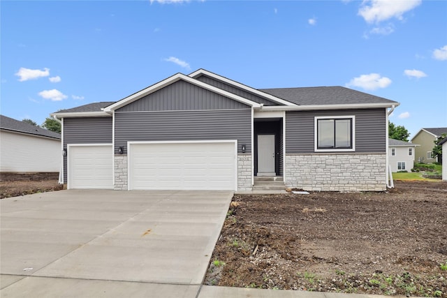 2323 N 8th Ave E, Newton, IA 50208 - ranch-style house with stone siding, an attached garage, concrete driveway, and entry steps
