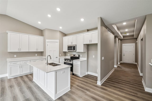 2323 N 8th Ave E, Newton, IA 50208 - kitchen with stainless steel appliances, white cabinetry, light countertops, a kitchen island with sink, and lofted ceiling