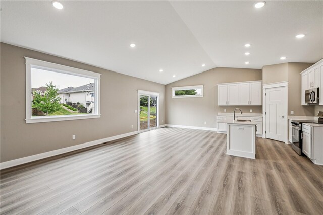 2323 N 8th Ave E, Newton, IA 50208 - kitchen with stainless steel appliances, open floor plan, light countertops, an island with sink, and lofted ceiling