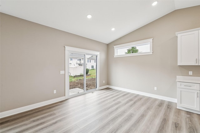 2323 N 8th Ave E, Newton, IA 50208 - unfurnished dining area with vaulted ceiling, light wood-style flooring, and recessed lighting