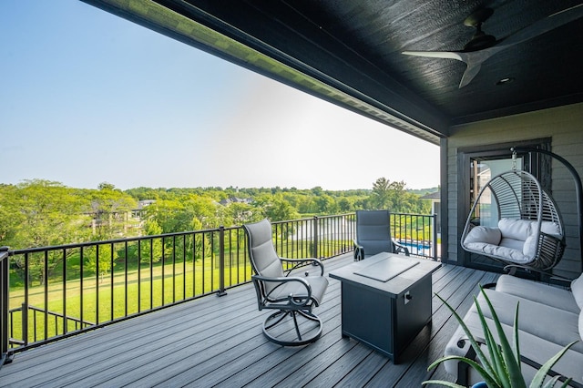 wooden terrace with a lawn and a ceiling fan