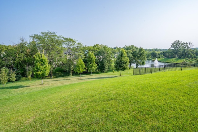 view of yard with fence and a water view