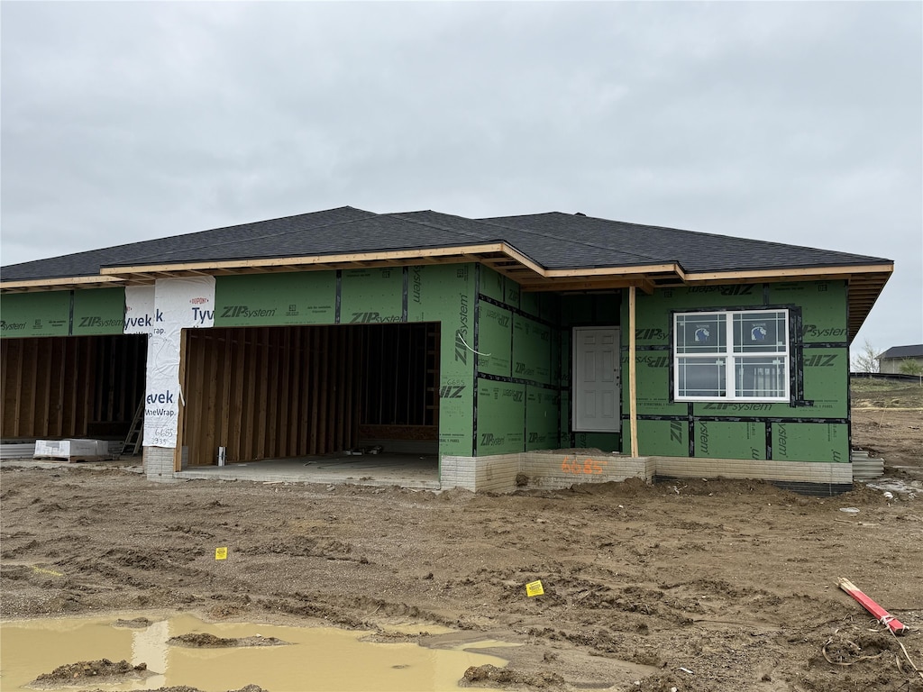 property in mid-construction with roof with shingles and an attached garage