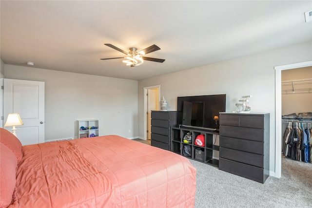 carpeted bedroom featuring a closet, a ceiling fan, visible vents, baseboards, and a spacious closet