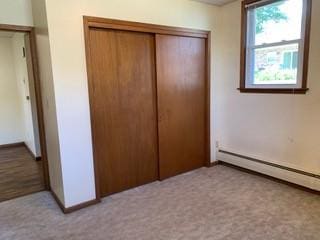 4713 Ontario St, Ames, IA 50014 - unfurnished bedroom with a closet, a baseboard heating unit, and baseboards