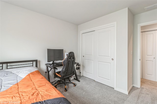 carpeted bedroom featuring a closet and baseboards