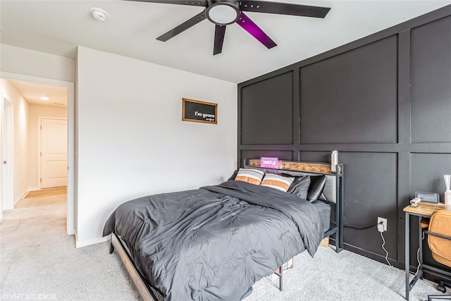 bedroom with ceiling fan, light carpet, and baseboards