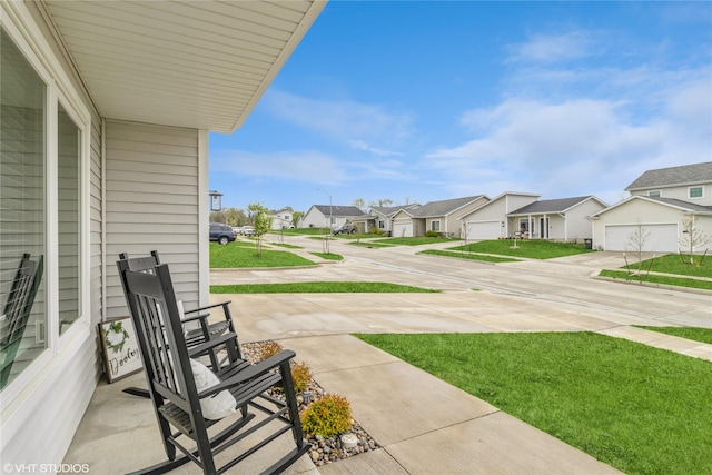 view of yard with a garage, a residential view, and driveway